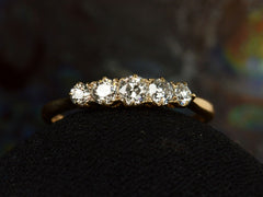 thumbnail of Front of antique c1900 ring with five small diamonds set in a row in 18K yellow gold. Shown on dark background.