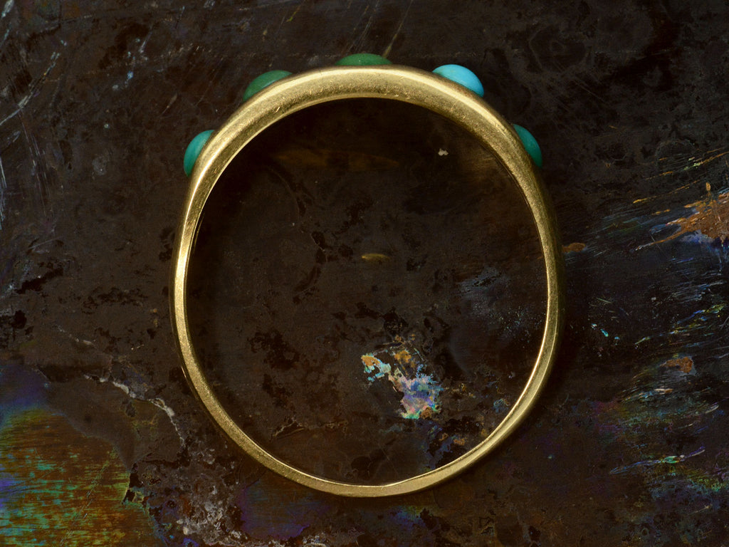 Side profile of c1900 18K Gold Ring with Five Oval Turquoise Cabochons, shown on dark background