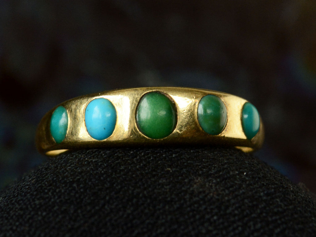 c1900 18K Gold Ring with Five Oval Turquoise Cabochons, shown on dark background