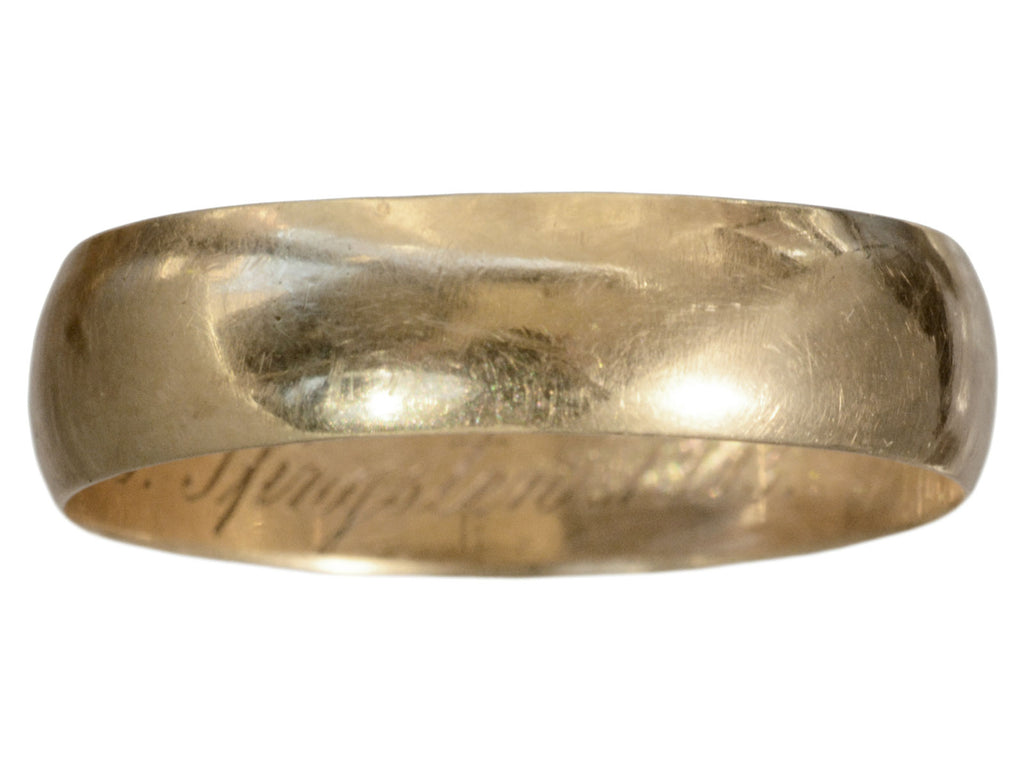 An antique 6.4mm wide rosy-yellow gold men's wedding band, shown on white background. An out of focus inscription is visible inside, but not legible.