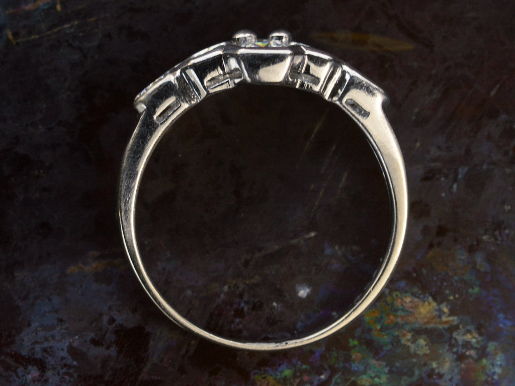 Side profile of c1960 white gold ring with a cluster of six diamonds. Shown on dark background.