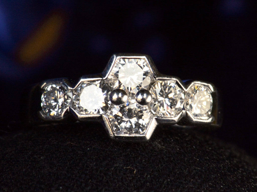 Vintage c1960 white gold ring with a cluster of six diamonds. Shown on dark background.