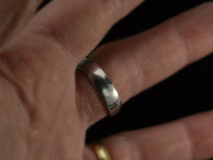thumbnail of Wide men's platinum band with matte surface on finger.