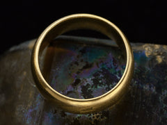 thumbnail of Side profile of a wide antique 18K yellow gold wedding band with patinated surface, shown on dark background.