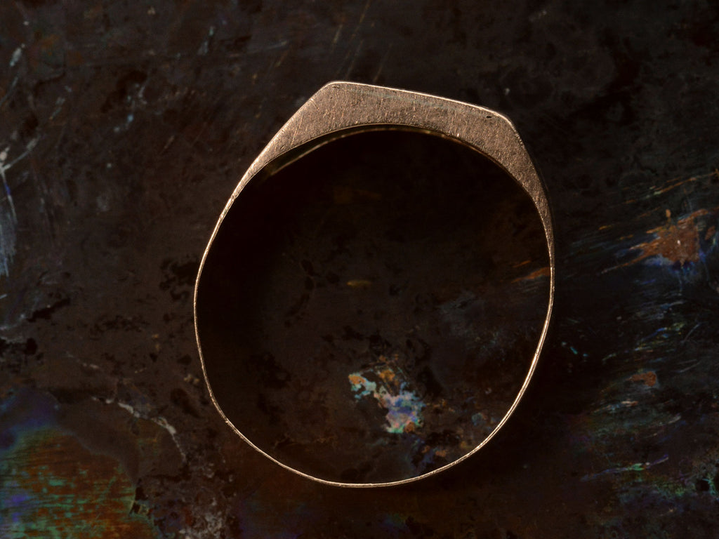 Side profile of c1890 Victorian signet ring in rose gold with black enamel details and the letter "B" on the face. Shown on dark background.
