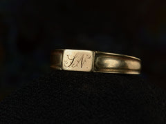 thumbnail of Right front angled view of a petite antique gold signet ring with the letters "I.N" engraved on a rectangular face. Shown on dark background.