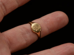 thumbnail of An antique 18K gold signet ring with a monogram (letters A and J) engraved on the face. Shown on finger.