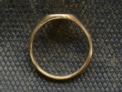 thumbnail of Side profile of an antique 18K gold signet ring. Shown on dark background.