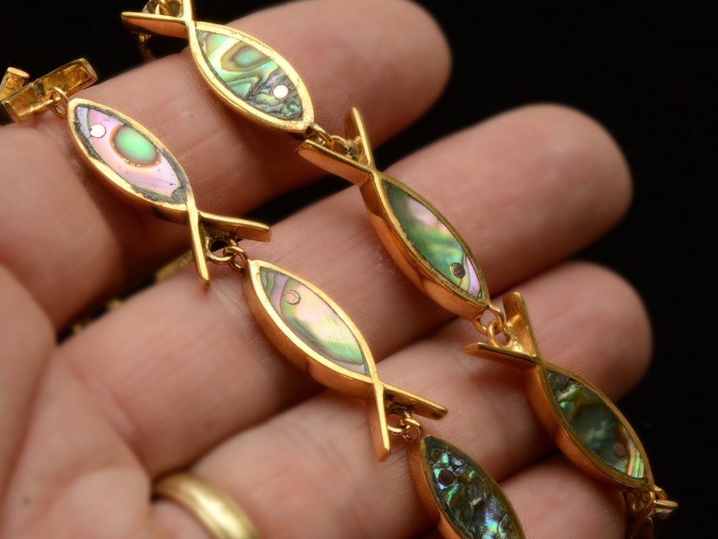 Detail view of c1970 Gilt Abalone Fish Necklace on Hand For Scale