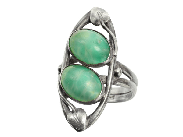 c1910 Arts & Crafts movement ring with a pair of oval green stones in a silver mounting with vines. On white background.