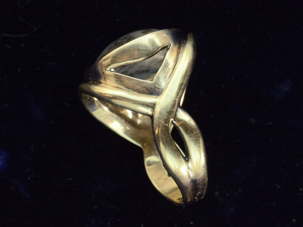 Shank view of oval dendritic agate ring in yellow gold. Shown on dark background.