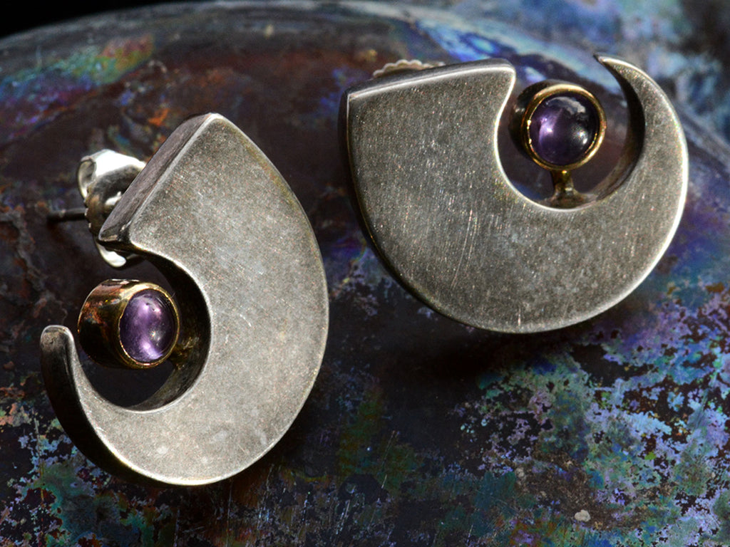 Detail view of c1990 Silver Claw Stud Earrings with Gold Bezel Mounted Purple Amethysts (on dark background)