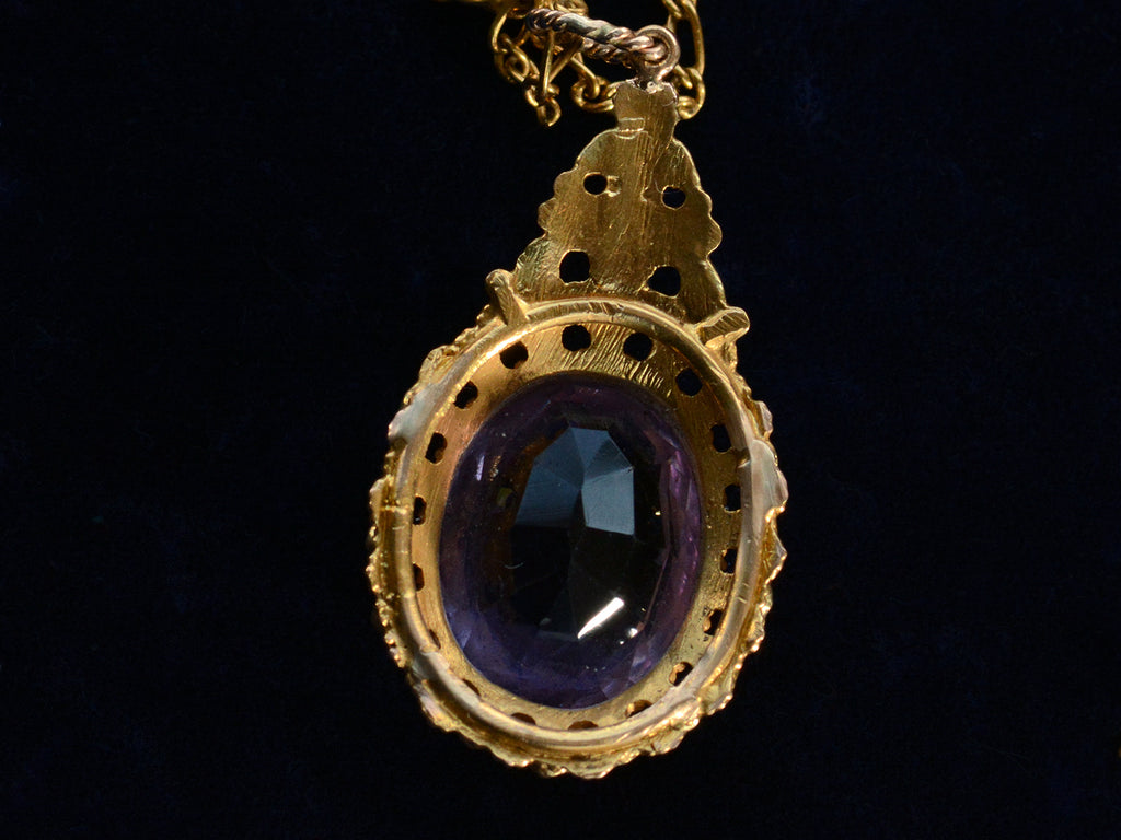 Detail of reverse side of c1880 oval amethyst and yellow gold pendant, shown on dark background.