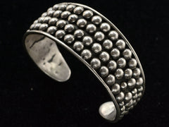 thumbnail of A vintage wide silver cuff bracelet featuring a textured, beaded outer band and a smooth polished inner band, shown against a solid black background.