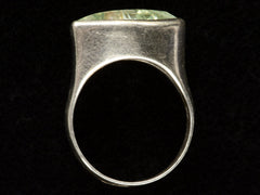 thumbnail of Side profile view of silver ring with faceted light green eye-shaped stone, shown on dark background.