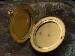 thumbnail of Inside of Victorian locket shown open on dark background.