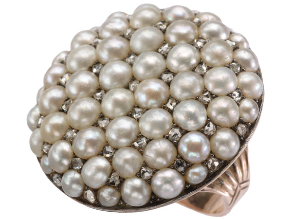 Angled view of Victorian ring with a large luster pearls and rose cut diamonds, set in rosy-yellow gold, shown on white background.