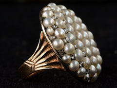 thumbnail of Left side view of Victorian ring with a large luster pearls and rose cut diamonds, set in rosy-yellow gold, shown on dark background.
