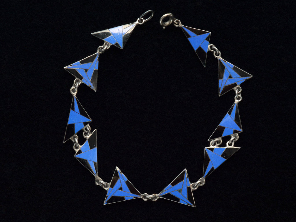 Detail of Art Deco silver bracelet with blue and black geometric triangle links on a black background
