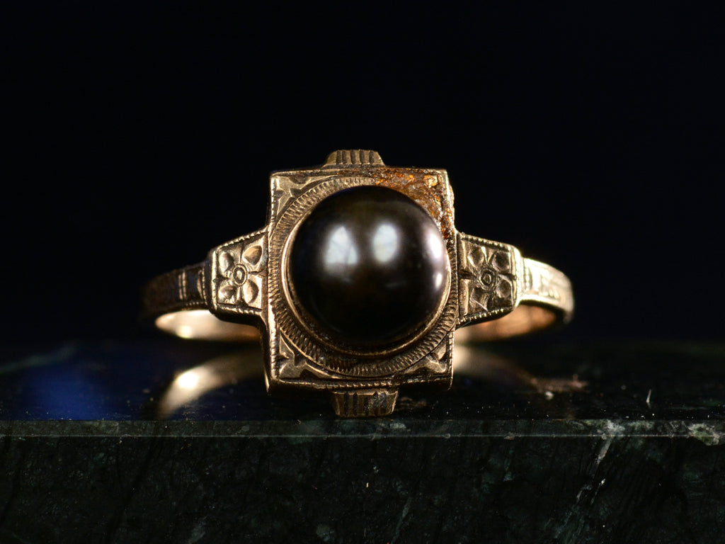 c1920 Art Deco black pearl ring in yellow gold (front view on dark background)