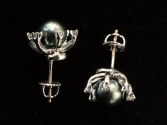 thumbnail of Side profile of  pair of vintage starburst stud earrings featuring a dark green-gray cultured pearls in a white gold prong setting, surrounded by six small clear diamonds on a black background.