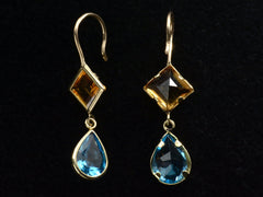 thumbnail of Reverse and angled views of gold earrings with diamond-shaped orange gem and teardrop-shaped blue gem on a black background