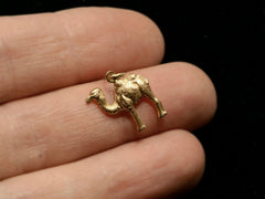 thumbnail of c1980 18K Camel Charm shown on hand for scale