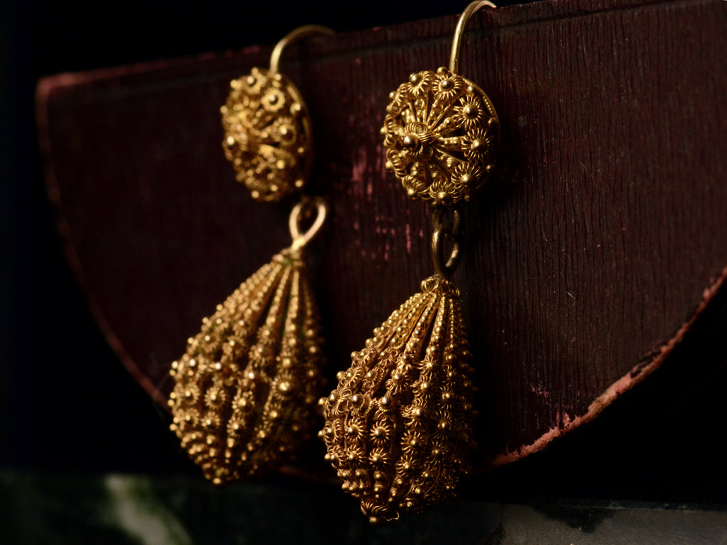 c1870 Yellow Gold Cannetille Drop Earrings (side angle view on dark red background)