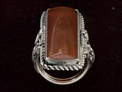 thumbnail of Side profile of vintage silver ring with intricate detailing and a long rectangular carnelian stone, shown on dark background.