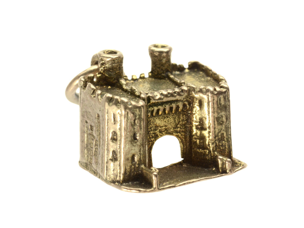 Front angled view of castle charm in gold, on white background.