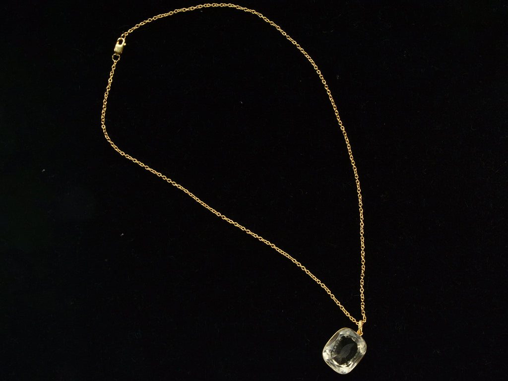 A c1820 Georgian era gold and crystal intaglio pendant and chain. Shown on black background.