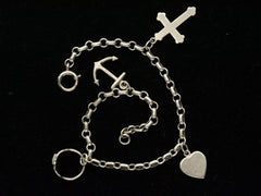 thumbnail of Detail view of c1930 Vintage Silver Charm Bracelet with 4 Charms: an Anchor, a Baby Ring, a Heart, and a Cross. Shown on black background.