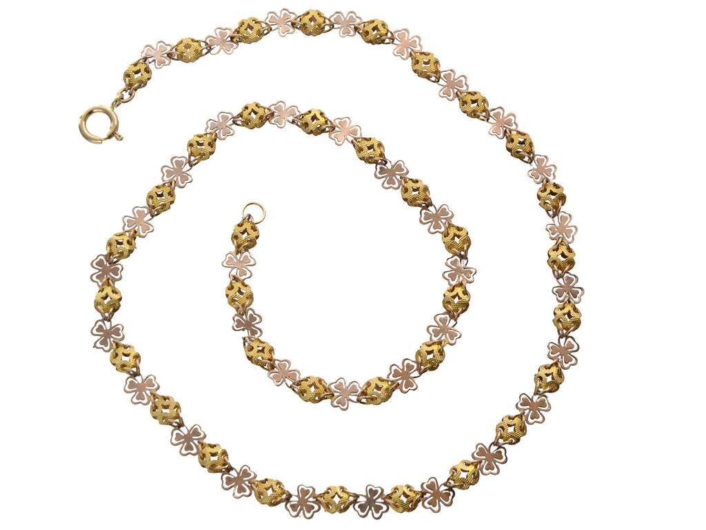 A Victorian c1880 Filigreed Rose and Yellow Gold Chain (shown spiraled on a white background)