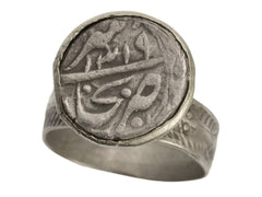thumbnail of Angled view of 18th Century Mughal Rupee with Arabic lettering, set in Silver Mounting (shown on white background)