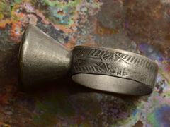 thumbnail of Side angle of Mughal Rupee Ring showing design on the shank, against colorful background.