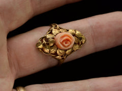 thumbnail of Front view of 1930 ring with a coral rose surrounded by gold leaves and vines, shown on finger.
