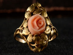 thumbnail of Front view of 1930 ring with a coral rose surrounded by gold leaves and vines, shown on black background.
