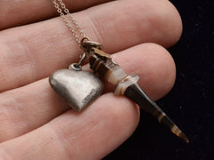 thumbnail of c1900 Heart & Dagger Charm Necklace (on hand for scale showing reverse side of heart) 