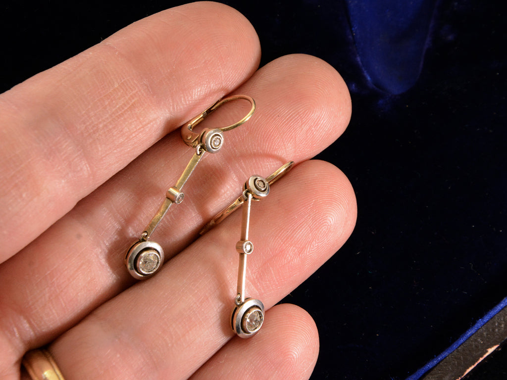 c1910 Diamond Drop Earrings in Platinum and 18K yellow gold, shown on hand for scale.