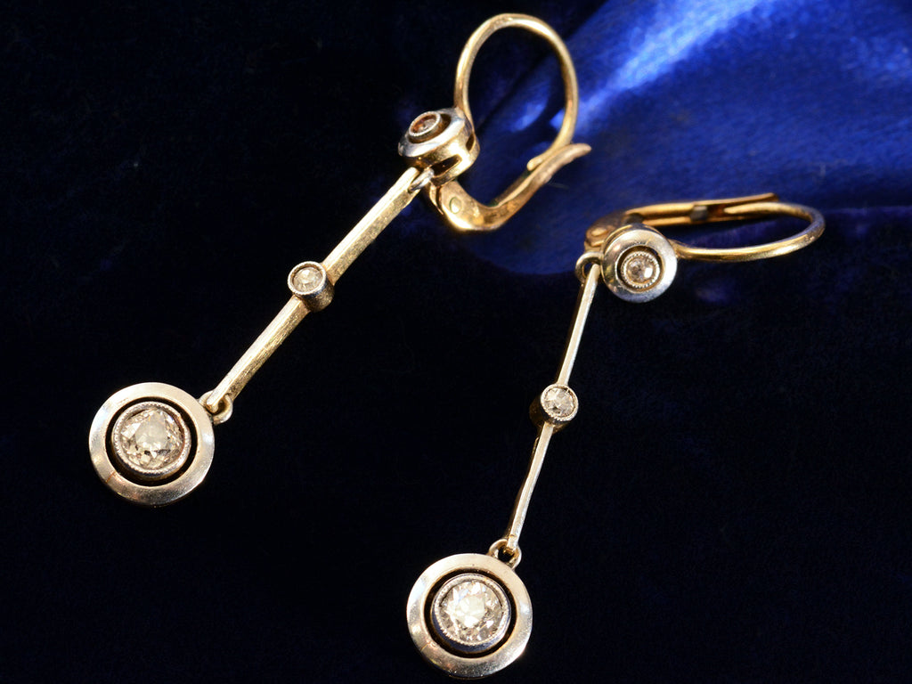 Detail view of c1910 Diamond Drop Earrings in Platinum and 18K yellow gold, shown on dark blue background