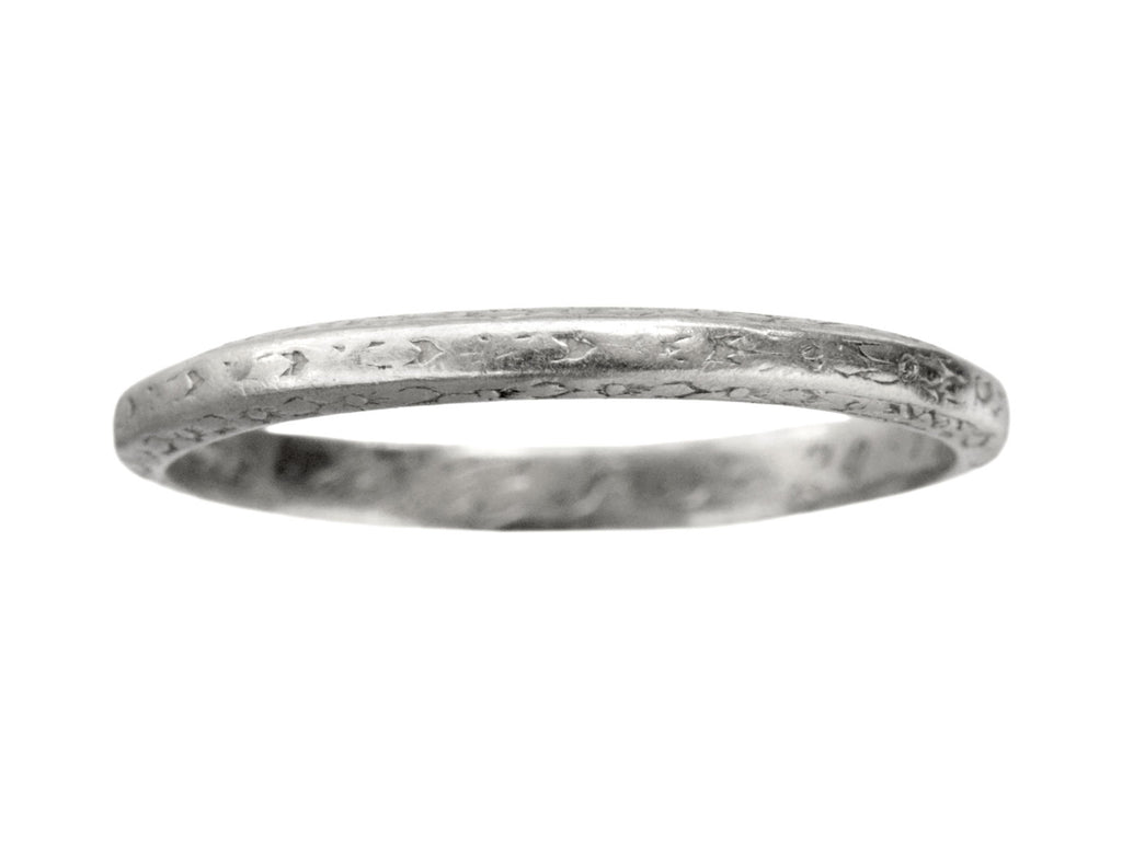 An antique platinum wedding band with engraved patterning, shown on white background.