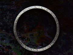 thumbnail of Side profile view of antique platinum wedding band with engraved patterning, shown on dark background.