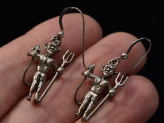 thumbnail of Pair of silver devil earrings with pitchforks, shown on hand.