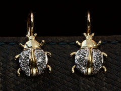 thumbnail of A pair of vintage bug-shaped earrings in yellow gold with white gold details and single cut diamonds set in the bodies. On dark background.