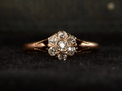 thumbnail of An antique rose gold Victorian ring with seven old European cut diamonds set in a cluster. Shown on dark background.