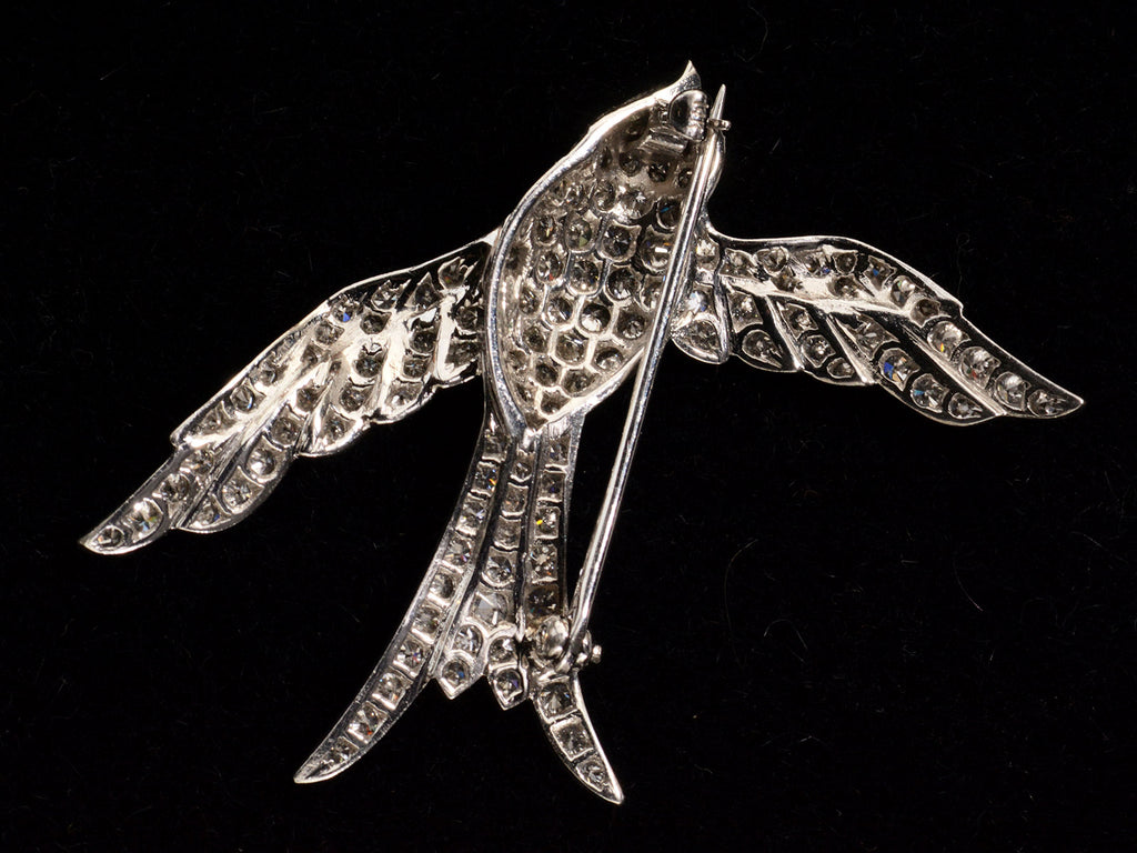 Reverse side of vintage c1950 diamond-studded bird-shaped brooch on a black. background. 14K mark visible on clasp.