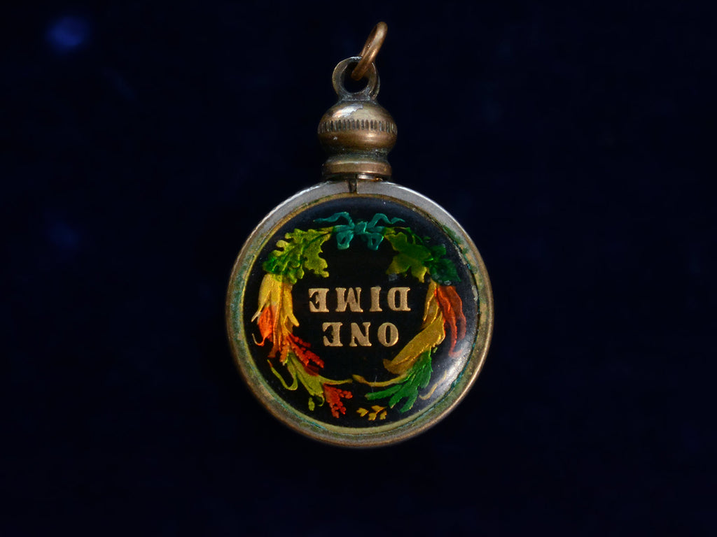 Opposite side of pendant with gilt and colorful enamel dime mounted in brass, shown on dark background. The words "One Dime" are visible on the dime.