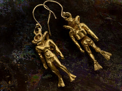 thumbnail of Pair of gold scuba diver earrings, one showing the backside, on dark iridescent background.