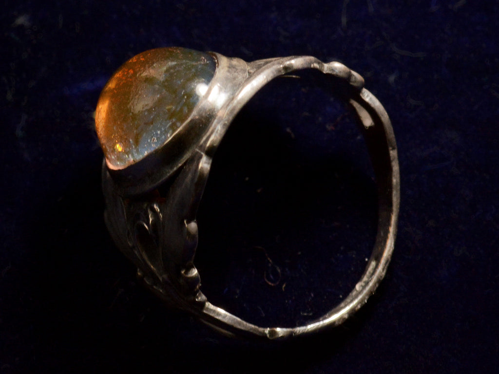 Side profile view of c1910 Dragon's Breath Ring (on dark background)