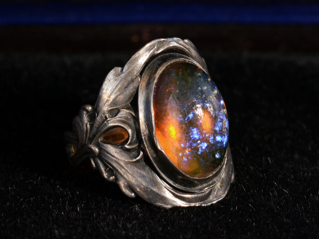 Left side view of c1910 Dragon's Breath Ring (showing purple iridescence and an orange glow)